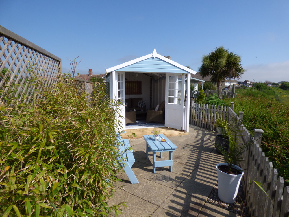 Blue skies above the beach hut at Pebble Cottage in Suffolk